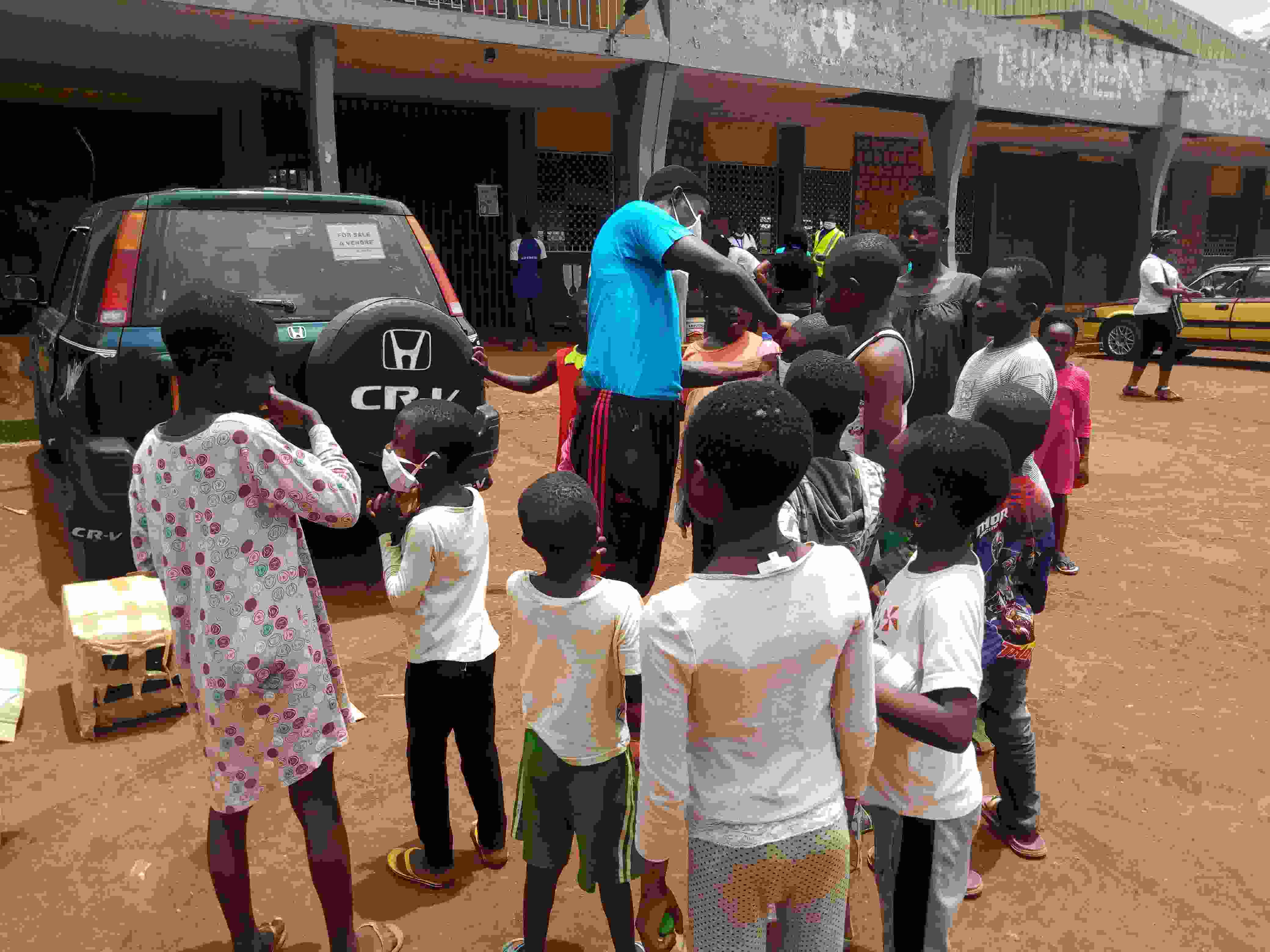 Muma Azehfor distributing mask to children